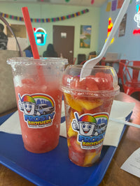 Customer enjoying a fresh fruit cup and refreshing watermelon agua fresca at Frosty Brothers in San Antonio. Made with fresh-cut fruit and handcrafted drinks, perfect for a healthy and refreshing snack.