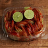 Prepared cucumber snack with fresh lime, chamoy, Tajín, and chili seasoning made fresh at Frosty Brothers Shaved Ice & Snacks.