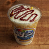 Creamy Mexican street corn in a cup with sweet corn, mayonnaise, butter, cotija cheese, and hot sauce, freshly prepared at Frosty Brothers Shaved Ice & Snacks in San Antonio, Texas.