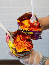 Hot Cheetos & Takis topped with warm nacho cheese, served fresh at Frosty Brothers Shaved Ice & Snacks in San Antonio, Texas.