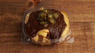 Classic Frito Pie with crunchy corn chips, warm chili, creamy nacho cheese, and sliced jalapeños, freshly prepared at Frosty Brothers Shaved Ice & Snacks in San Antonio, Texas.