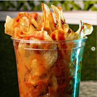 Crispy Papas Locas maggie sauce, lime and salsa inglesa, hot sauce, and flavorful toppings, freshly prepared at Frosty Brothers Shaved Ice & Snacks in San Antonio, Texas.