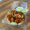 Prepared cucumber snack with fresh lime, chamoy, Tajín, and chili seasoning made fresh at Frosty Brothers Shaved Ice & Snacks on a table.