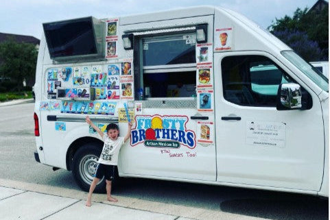 Birthday boy smiling in front of the Frosty Brothers ice cream truck during a special celebration in a San Antonio neighborhood.