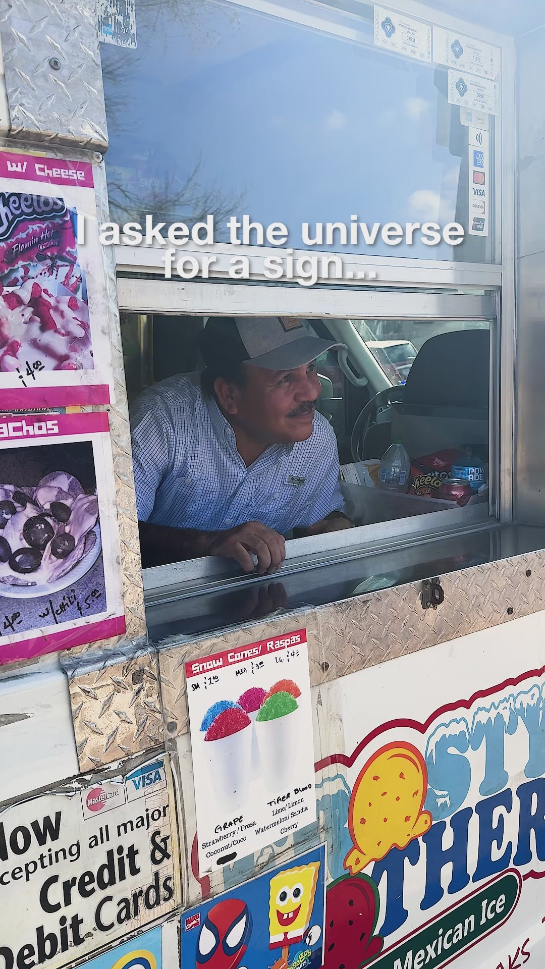 Video of Carlos Sr. smiling from the Frosty Brothers Ice Cream Truck service window during a catering event in San Antonio, featuring shaved ice, snacks, and family-owned service.
